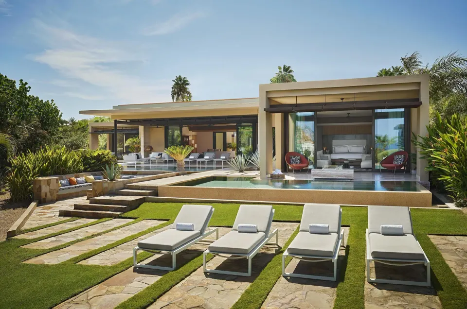 Casa Dolphin exterior at Montage Los Cabos with lawn loungers, pools, and an open bedroom.