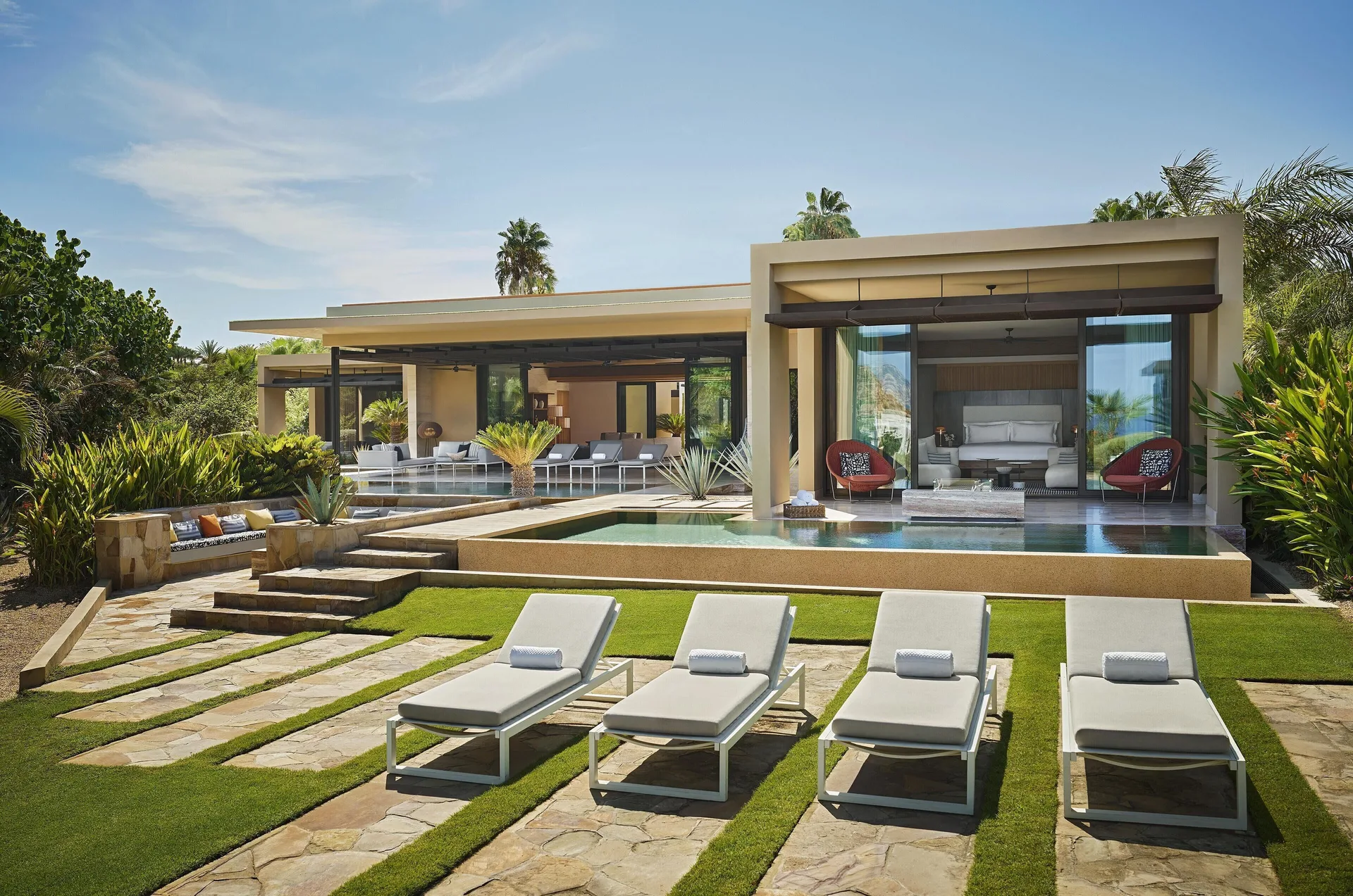 Casa Dolphin exterior at Montage Los Cabos with lawn loungers, pools, and an open bedroom.