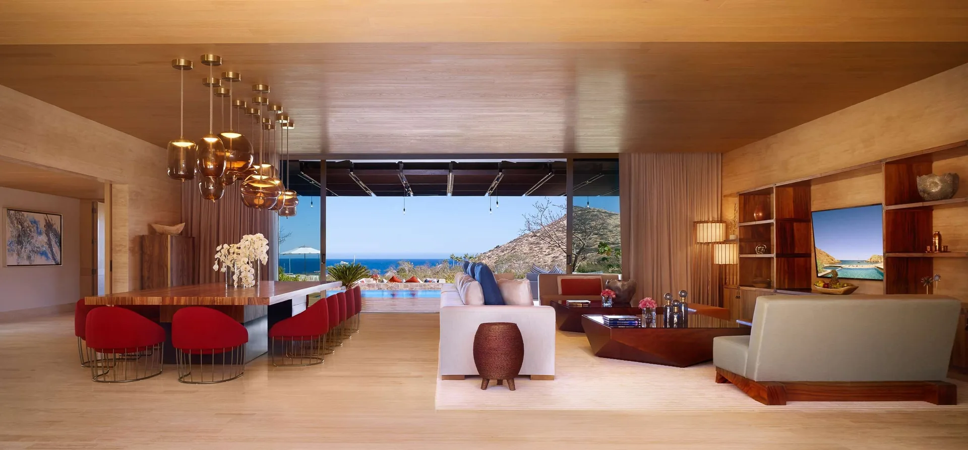 Casa Dolphin great room at Montage Los Cabos with dining bar, lounge seating, pool, and ocean view.