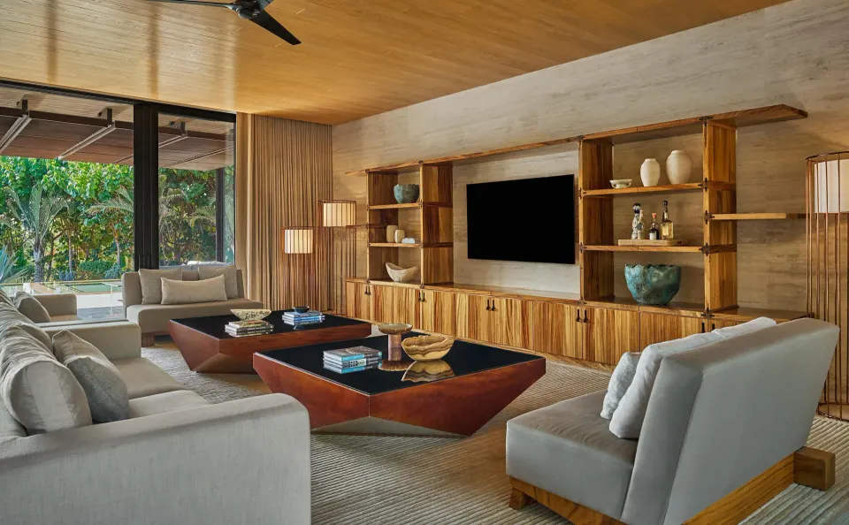 Casa Dolphin living room at Montage Los Cabos with sofas, media wall, and garden-facing glass doors.
