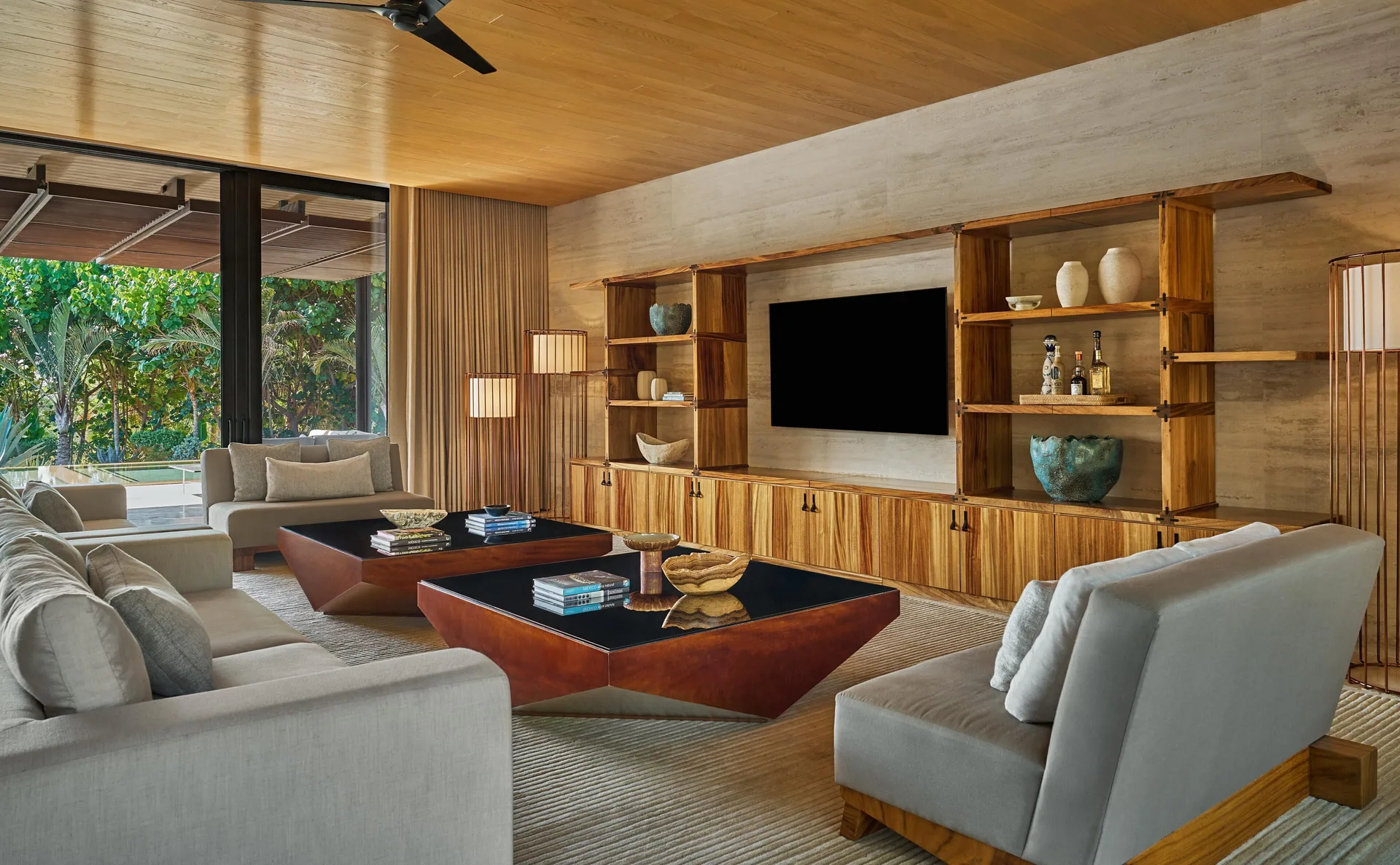 Casa Dolphin living room at Montage Los Cabos with sofas, media wall, and garden-facing glass doors.