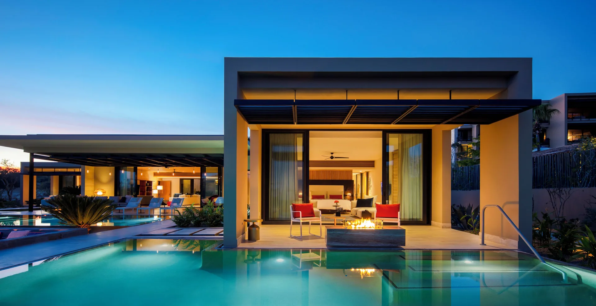 Casa Dolphin exterior at Montage Los Cabos with pool, patio seating, and fire feature at dusk.