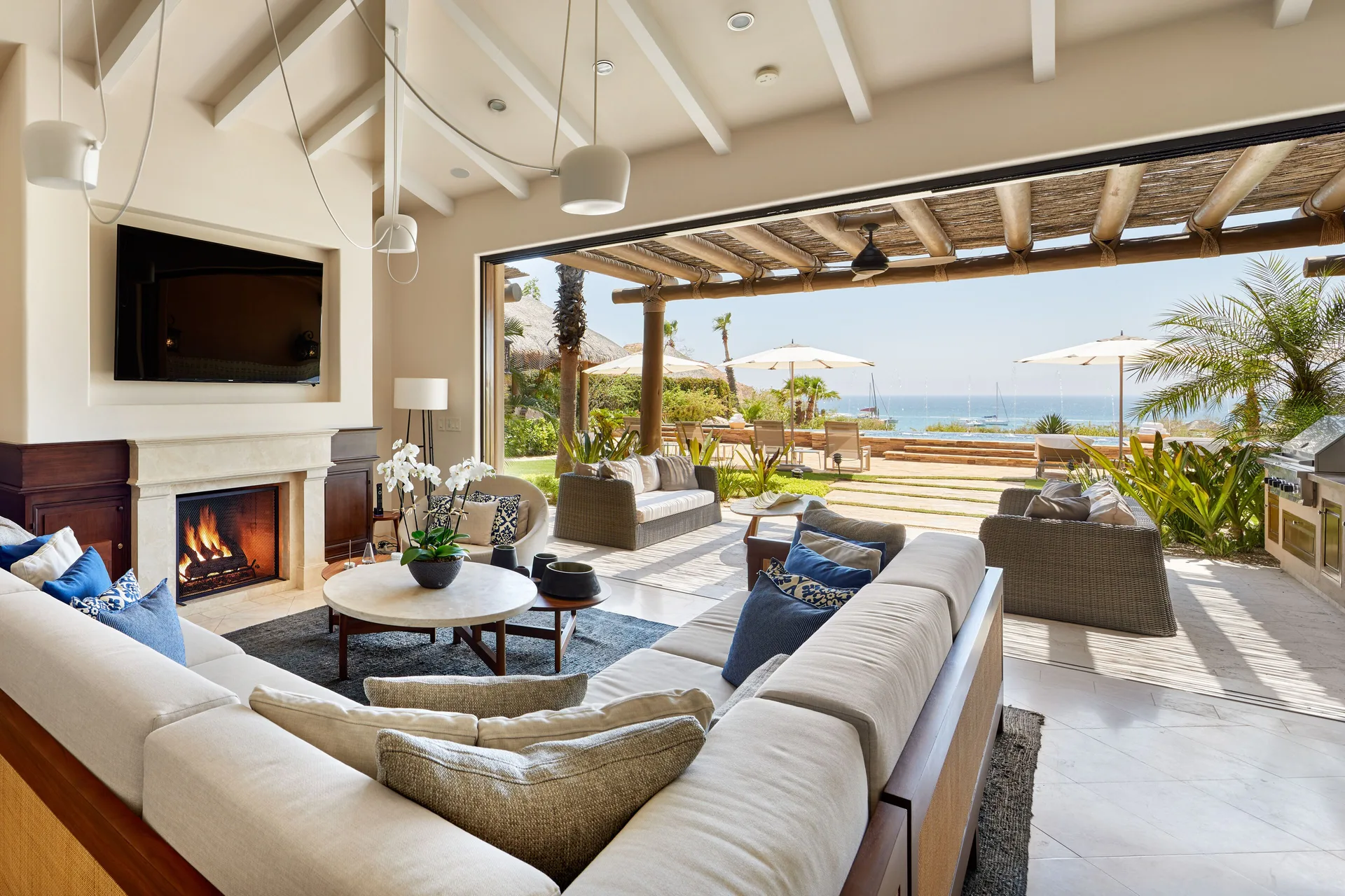 Casa Santa Maria indoor-outdoor living room at Montage Los Cabos with fireplace and ocean view.