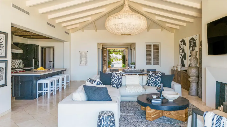 Casa Santa Maria living room and kitchen at Montage Los Cabos with vaulted ceiling and sectional sofa.
