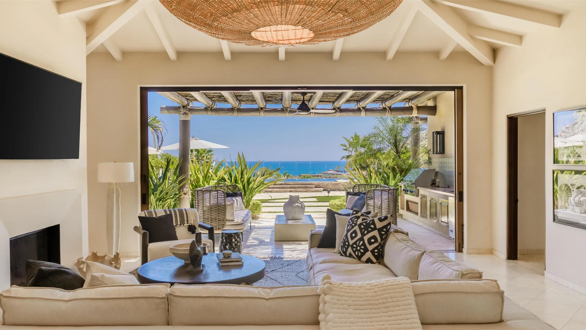 Living room of Casa Santa Maria at Montage Los Cabos opening to a terrace and ocean view.