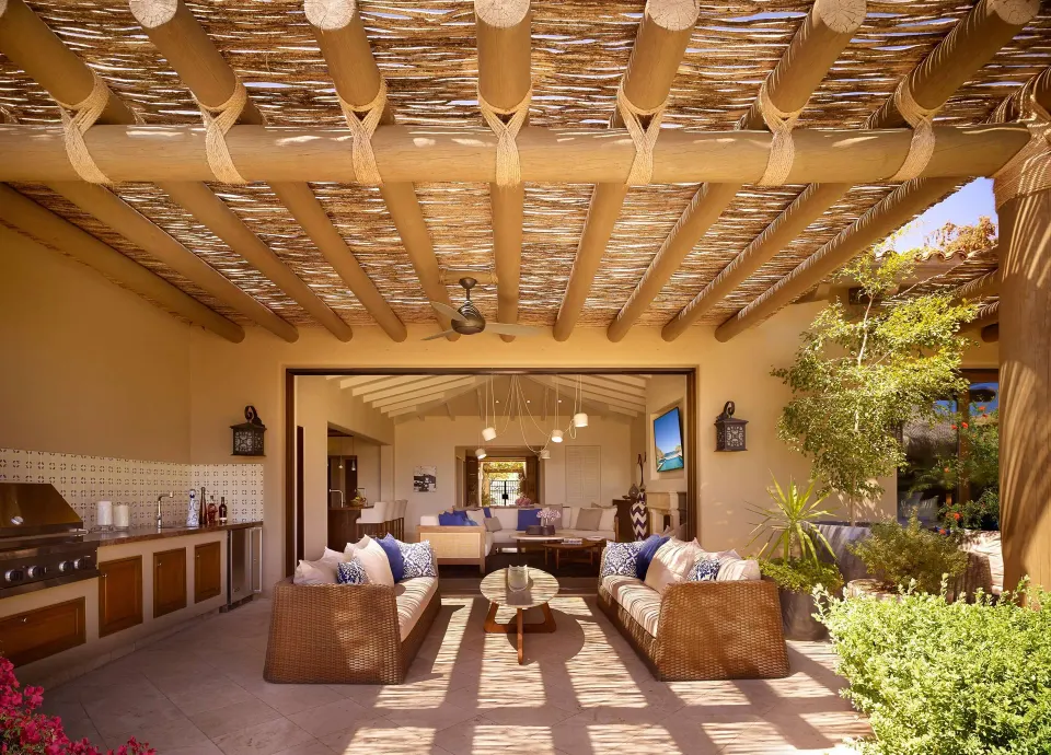 Covered outdoor living area of Casa Santa Maria at Montage Los Cabos with sofas and grill.