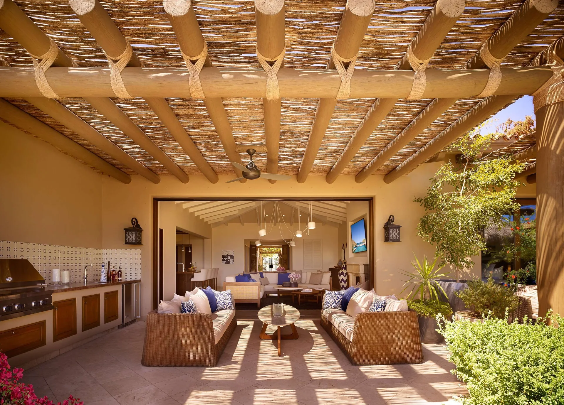 Covered outdoor living area of Casa Santa Maria at Montage Los Cabos with sofas and grill.