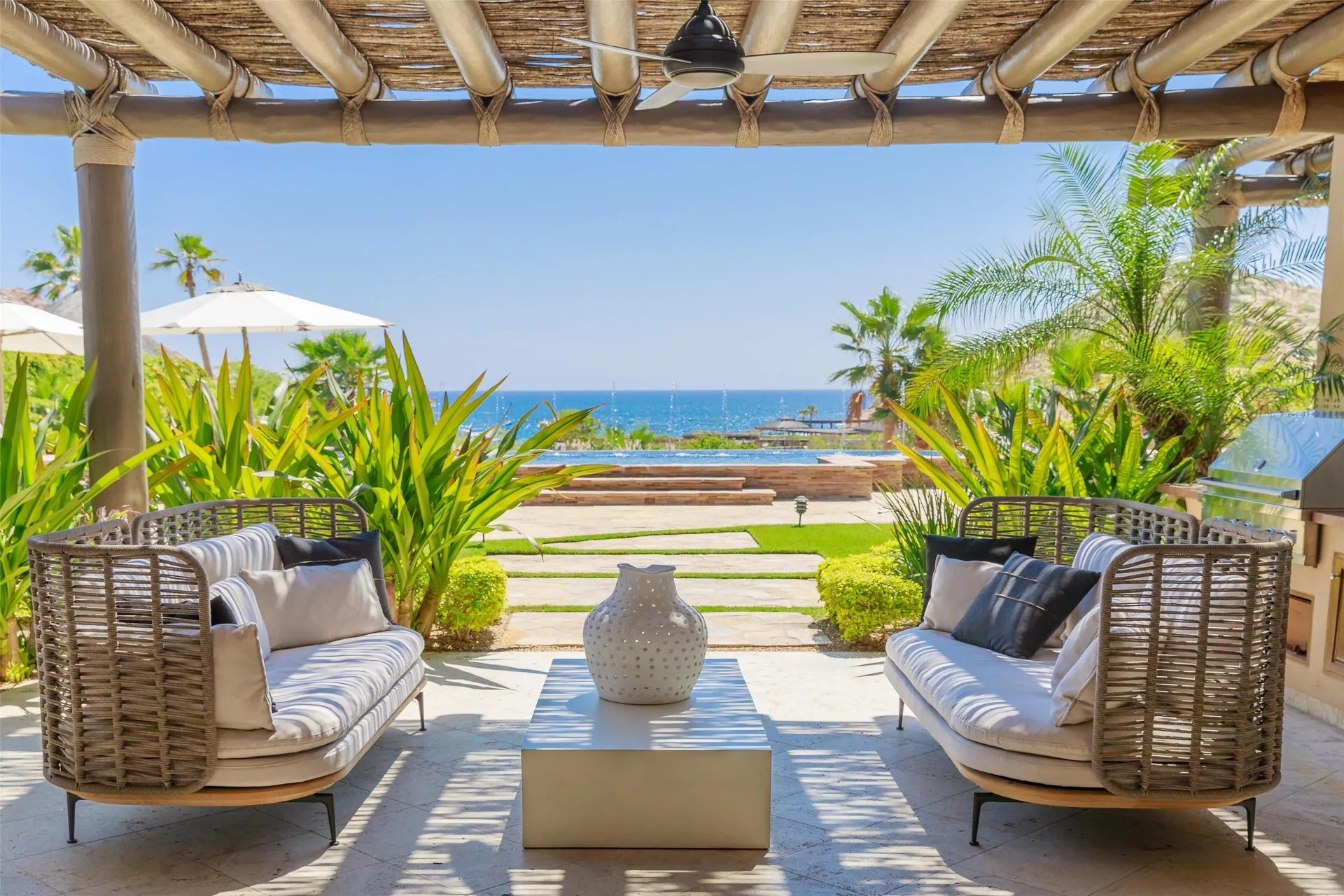 Shaded terrace of Casa Santa Maria at Montage Los Cabos with seating and ocean beyond.