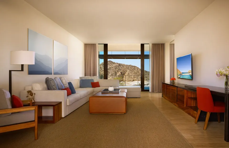 Deluxe Ocean View One Bedroom Suite living room with sofa and desk at Montage Los Cabos.