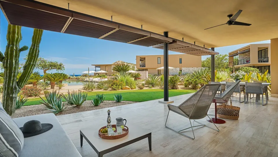 Deluxe Ocean View Two Bedroom Suite patio with lounge chairs and garden view at Montage Los Cabos.