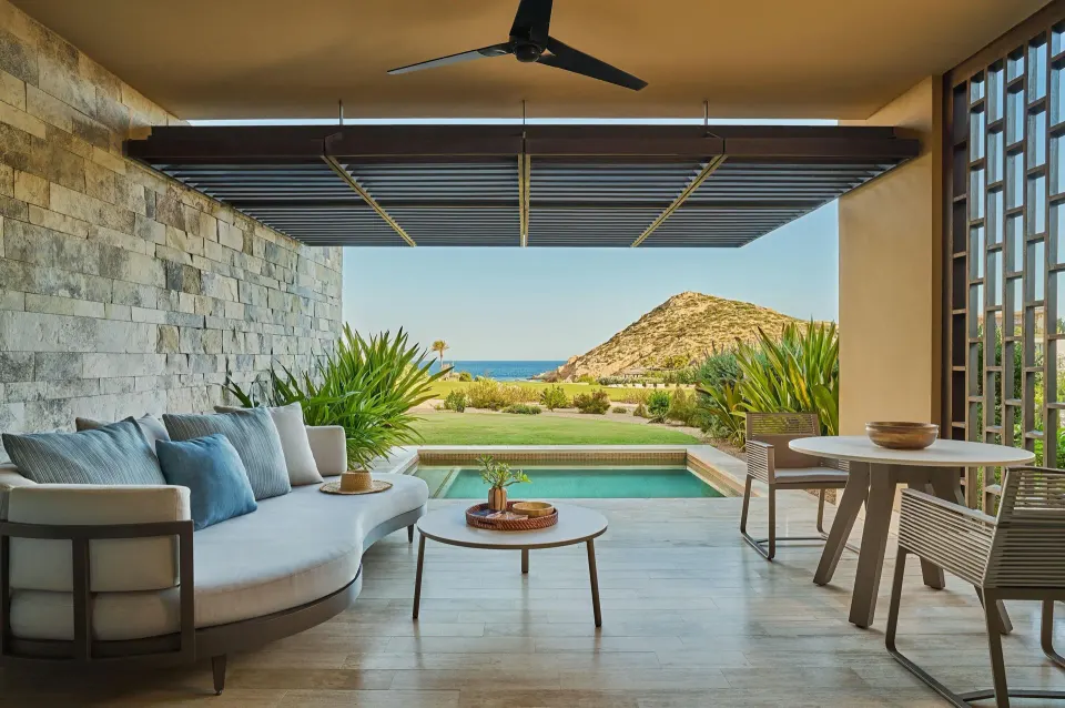 Deluxe Ocean View with Pool terrace at Montage Los Cabos with plunge pool, dining set, sofa and rocky headland.
