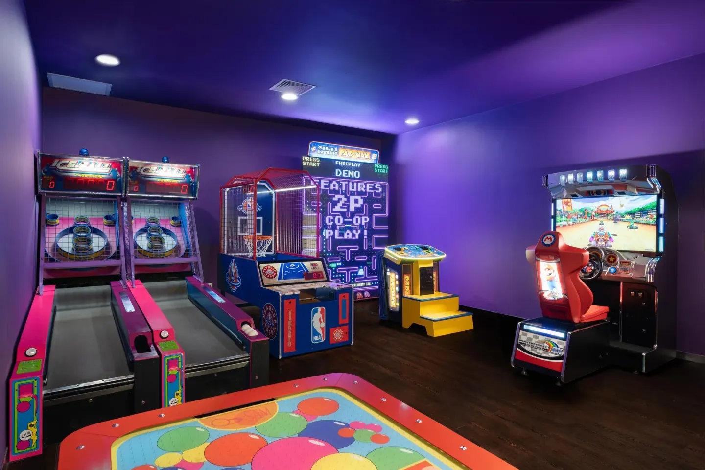 Arcade machines line a purple game room at Moon Palace Cancun.