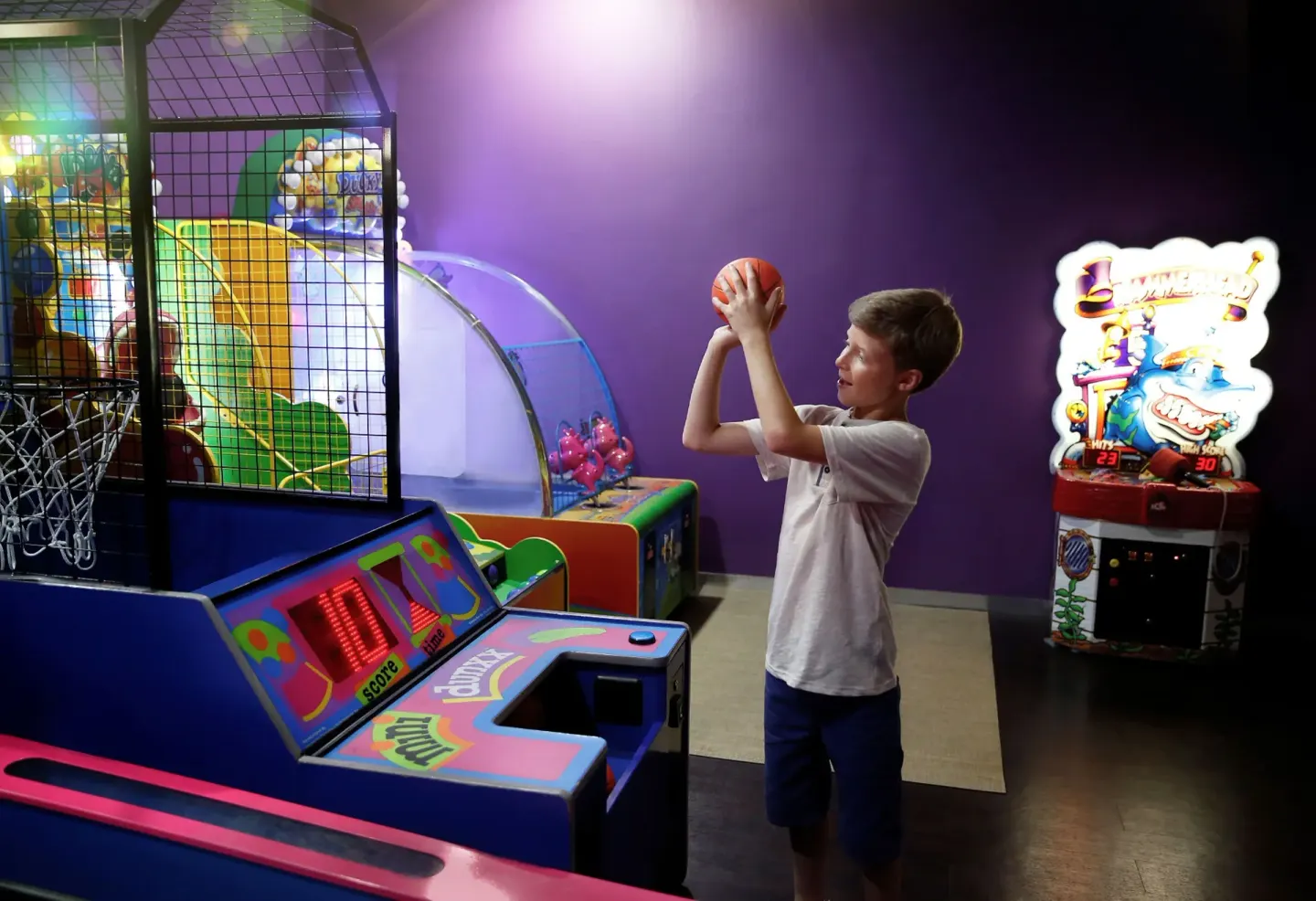 A child shoots a basketball arcade game in the play area at Moon Palace Cancun.
