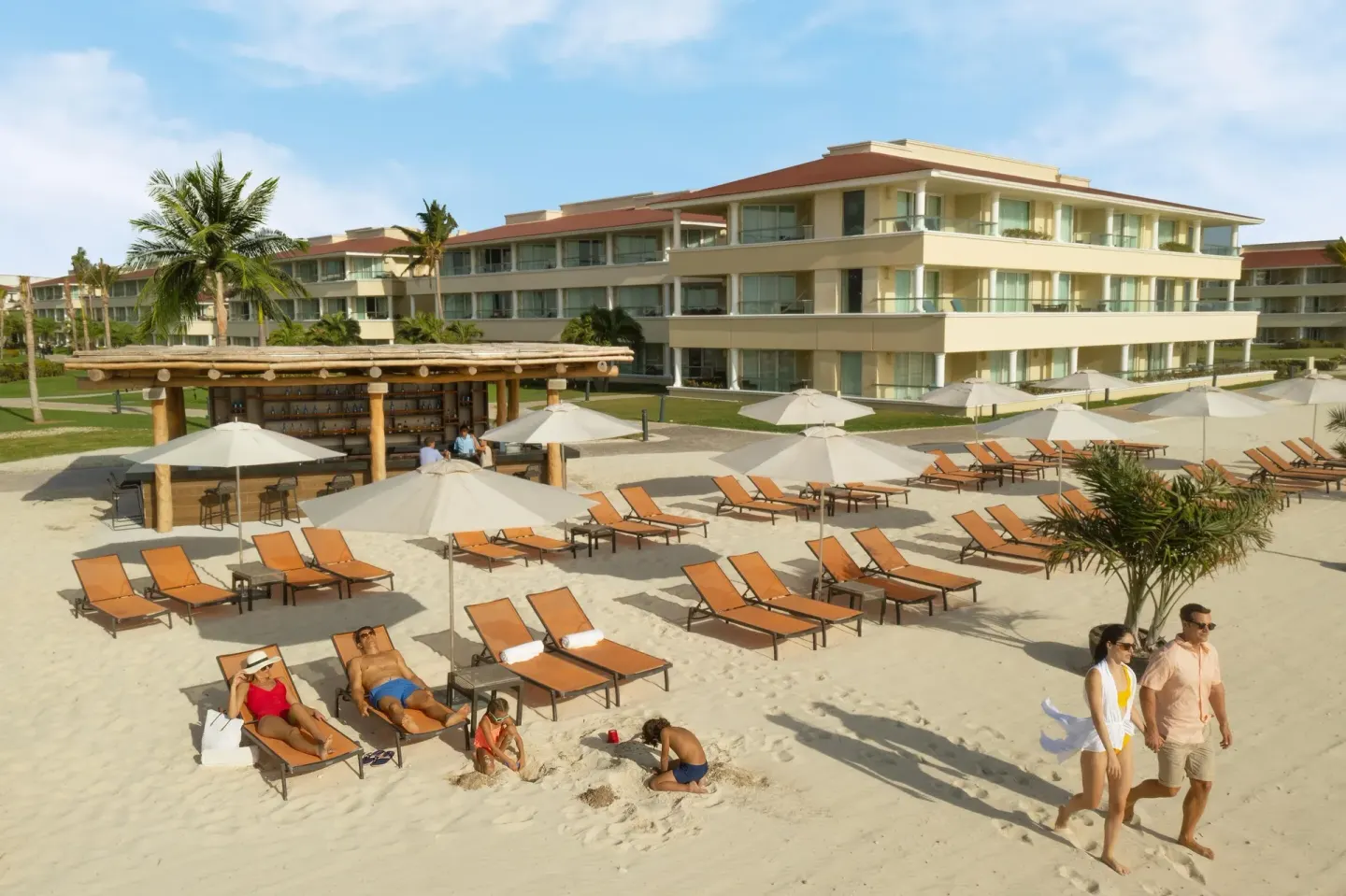 Beach loungers, umbrellas, bar hut, and guest buildings at Moon Palace Cancun.