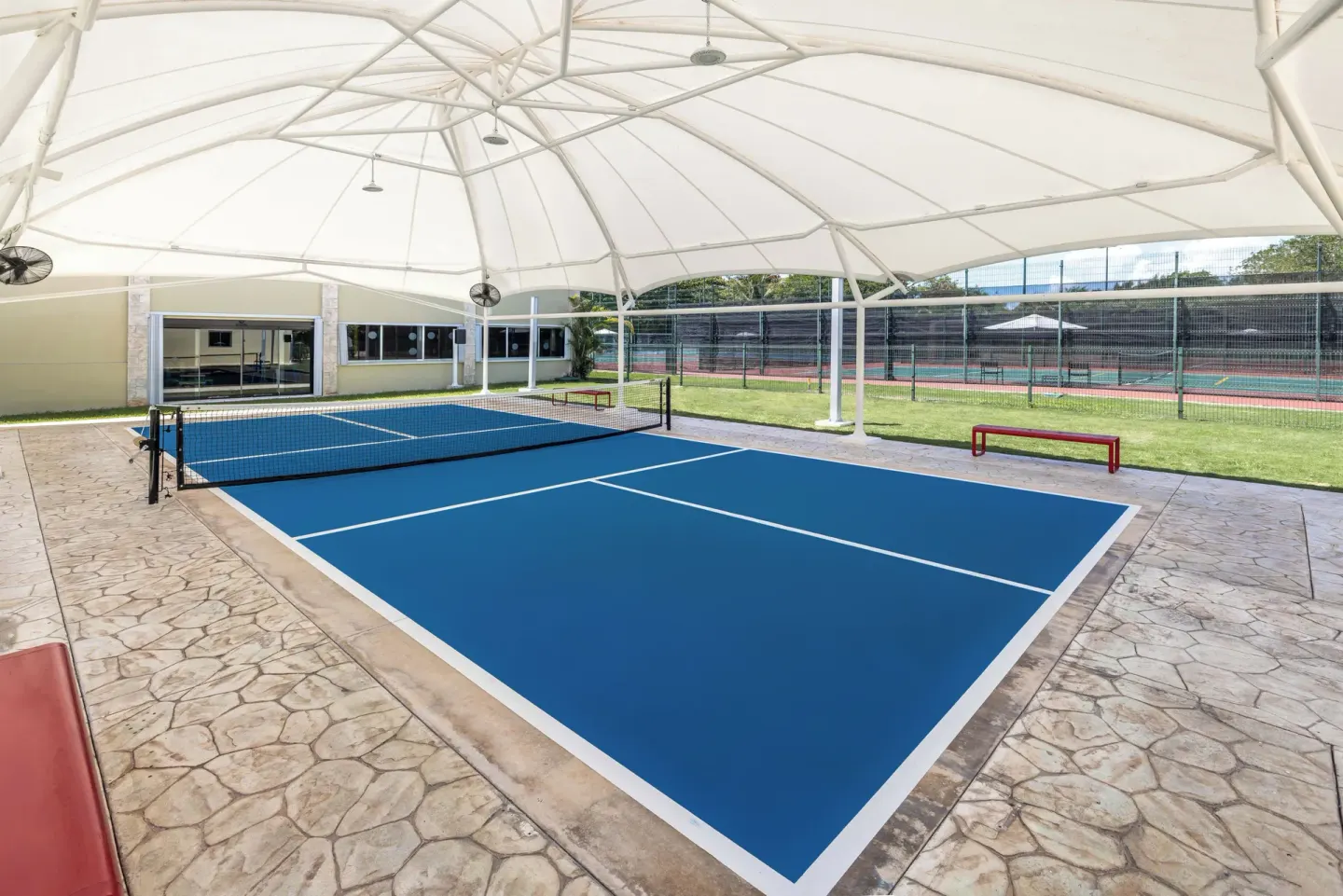 Covered blue sports court with netting at Moon Palace Cancun.