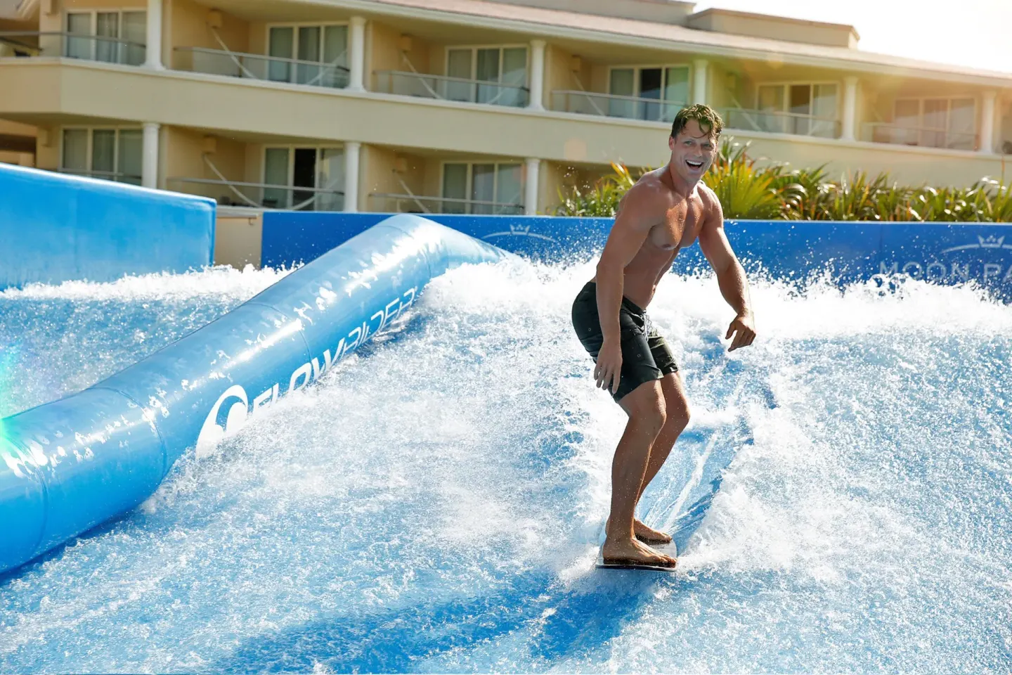 Guest riding a FlowRider surf simulator at Moon Palace Cancun.