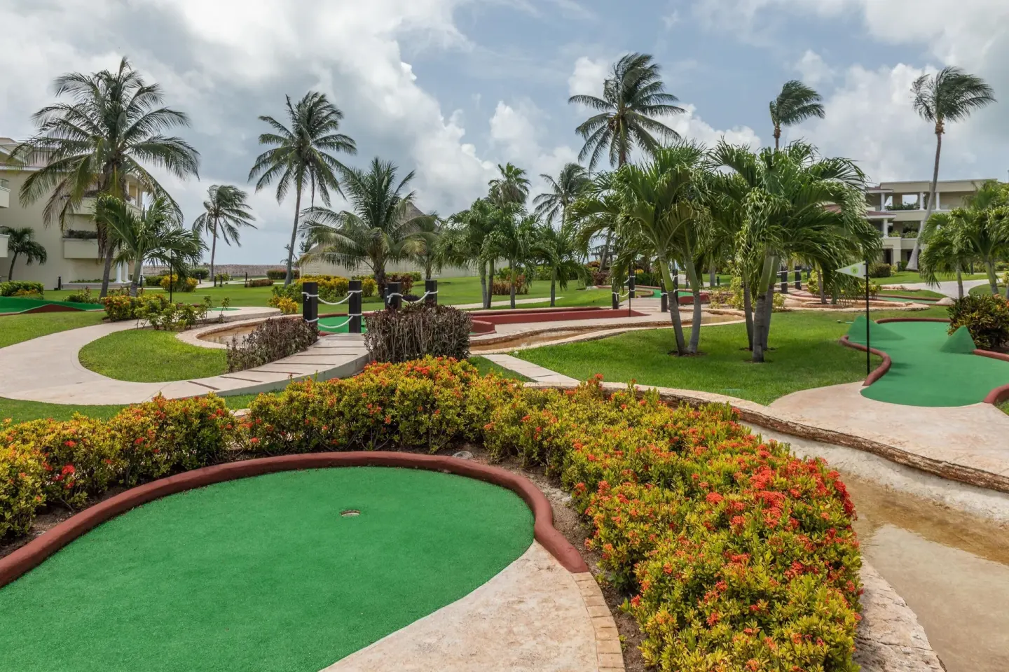 Mini golf greens wind through palms and landscaping at Moon Palace Cancun.