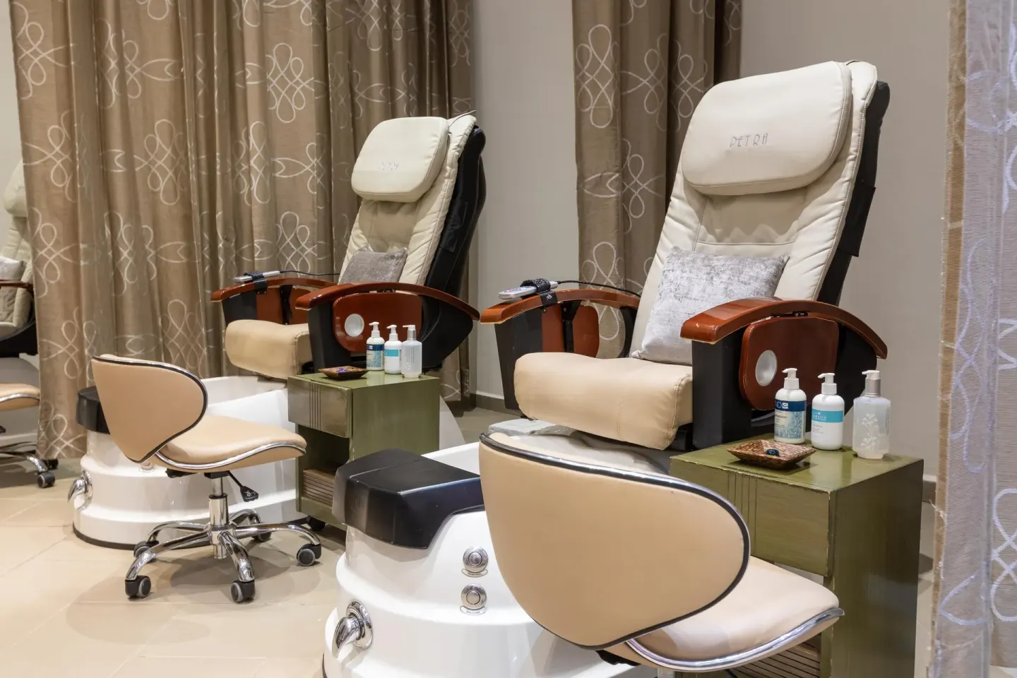 Pedicure chairs with foot basins and side tables at Moon Palace Cancun.