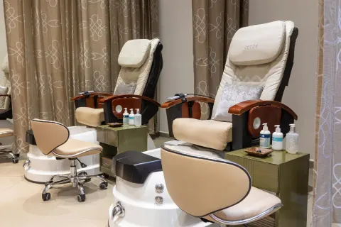 Pedicure chairs with foot basins and side tables at Moon Palace Cancun.