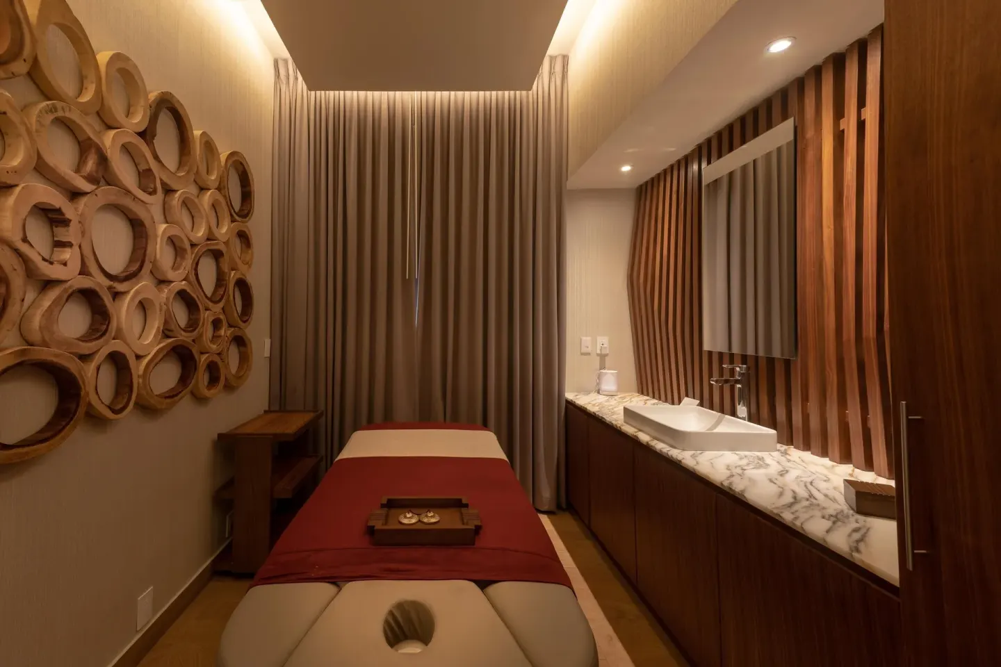 Single spa treatment room with sink counter and wood wall art at Moon Palace Cancun.