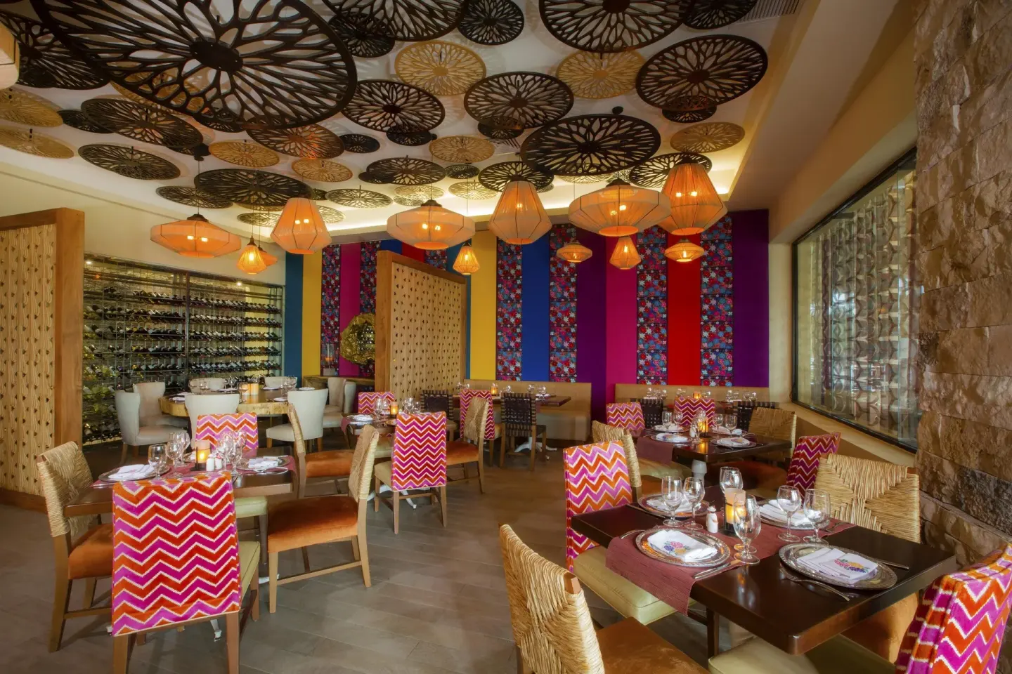Colorful restaurant dining room with patterned chairs and ceiling decor at Moon Palace Cancun.