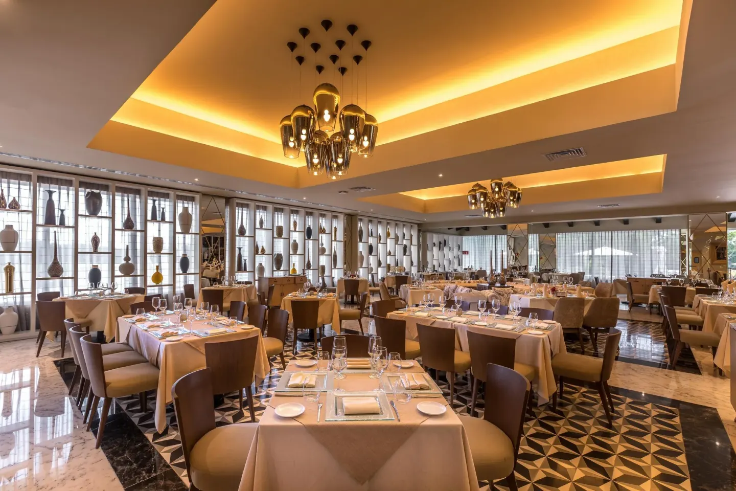 Elegant restaurant dining room with set tables and chandeliers at Moon Palace Cancun.