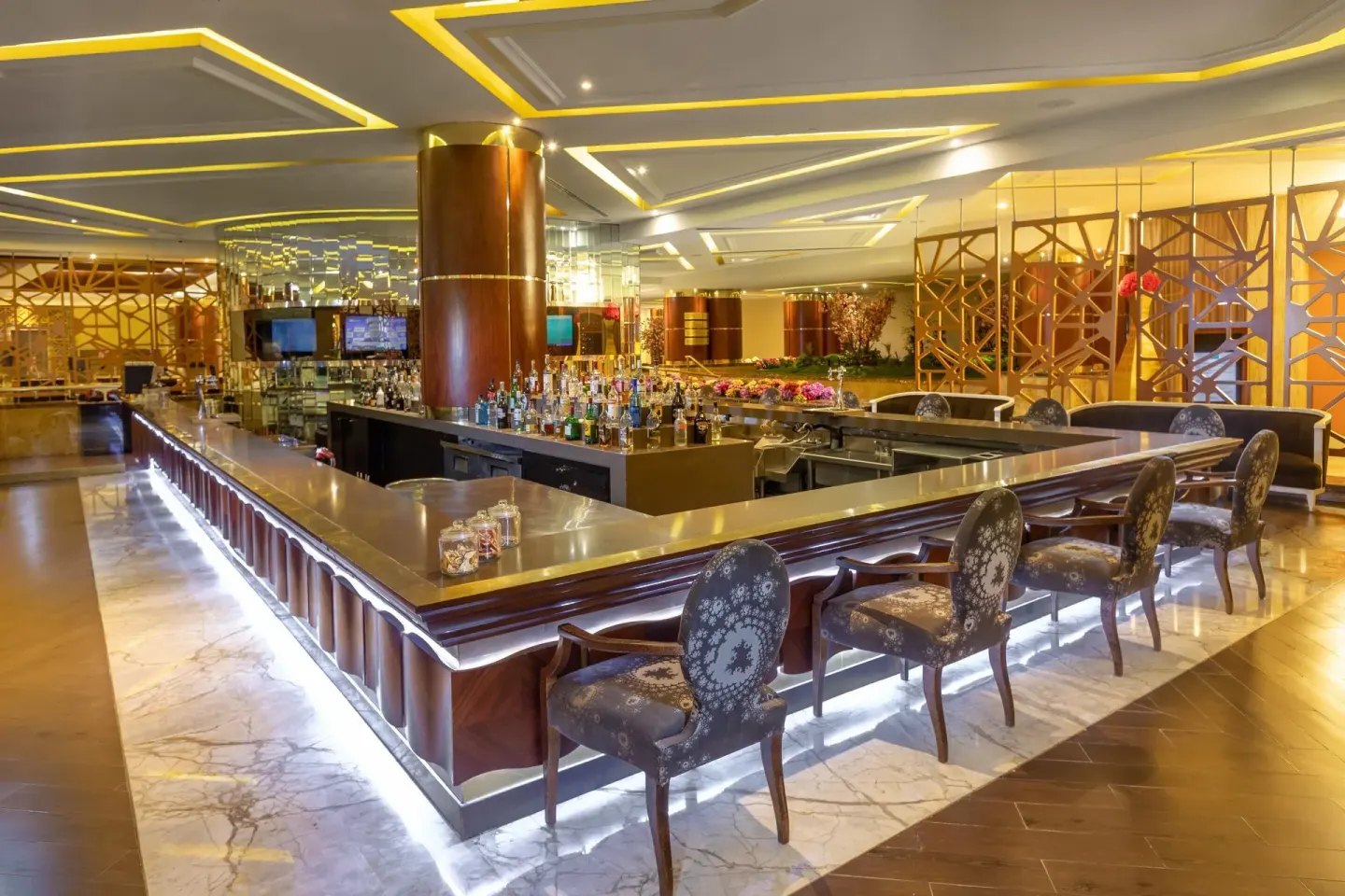 Long polished bar with bottles and patterned seating at Moon Palace Cancun.