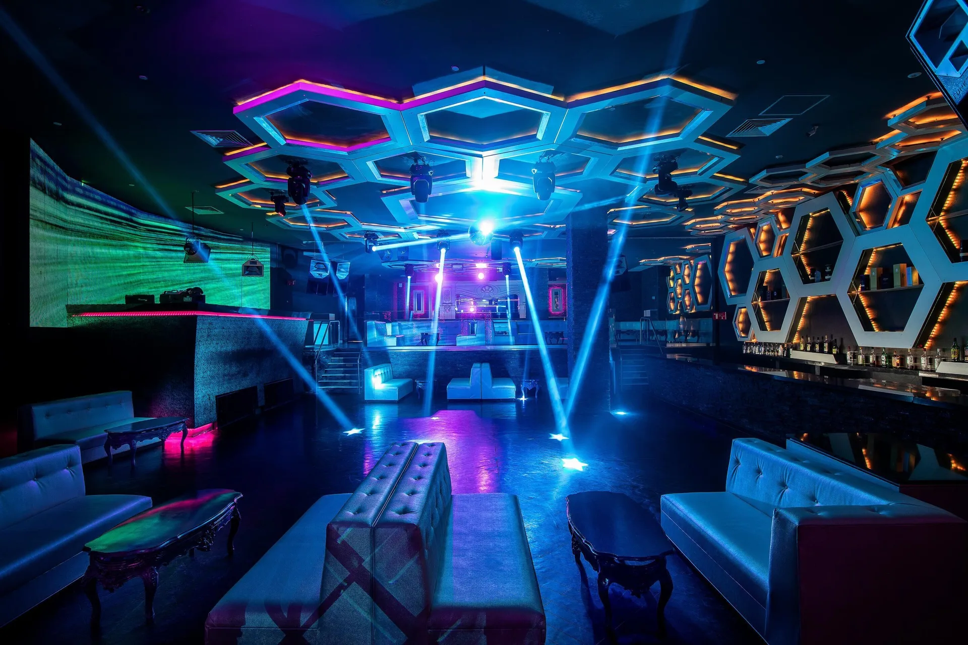 Nightclub lounge with blue spotlights and hexagon ceiling at Moon Palace Cancun.
