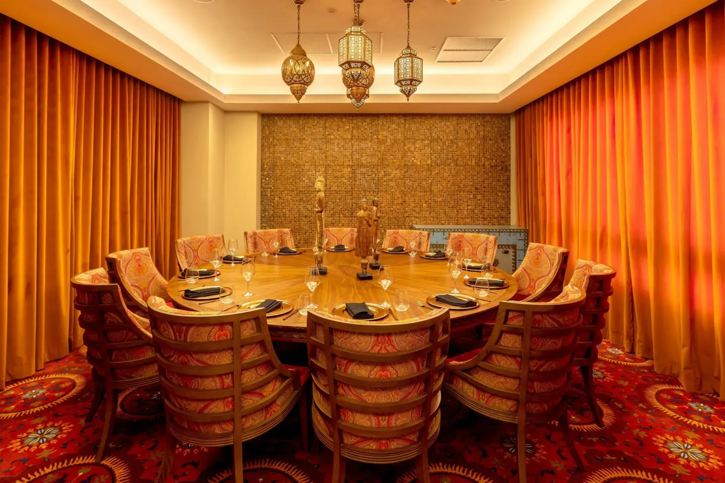 Private dining room with a round table and patterned orange seating at Moon Palace Cancun.