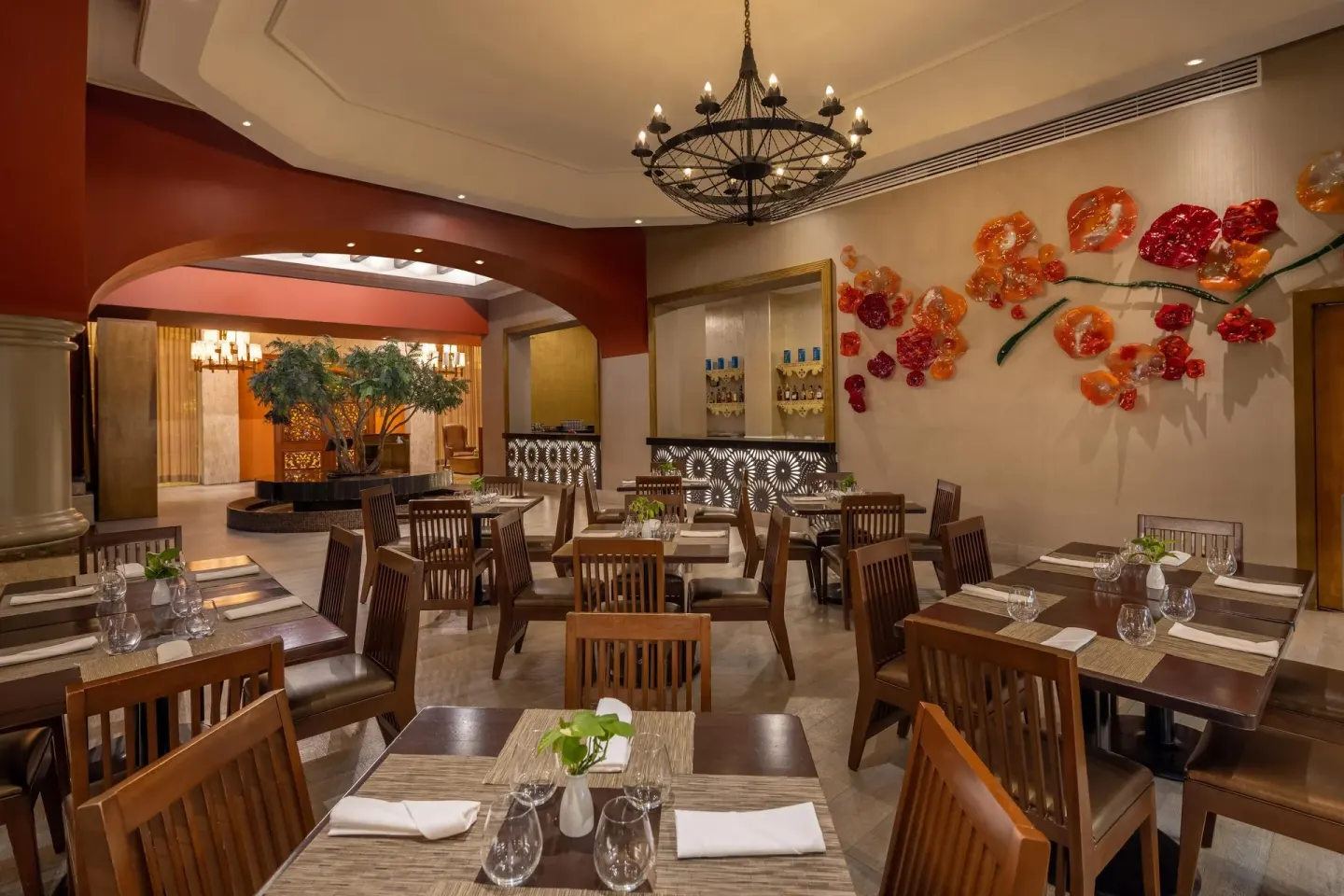 Restaurant dining room with wood chairs and colorful wall flowers at Moon Palace Cancun.