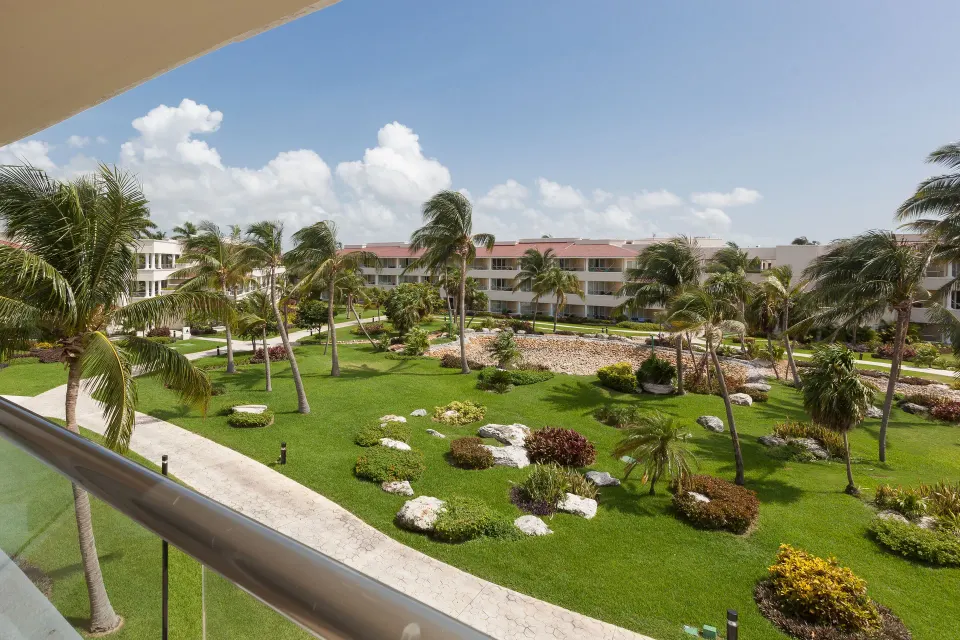 Garden view from a Superior Deluxe balcony at Moon Palace Cancun with palms and resort buildings.