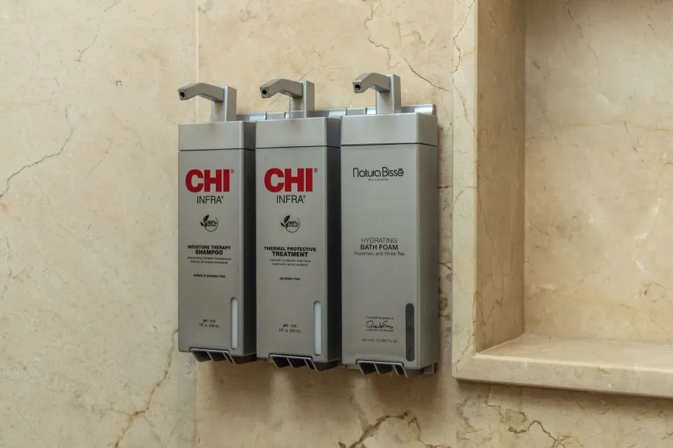 Wall-mounted shower amenity dispensers in a room bathroom at Moon Palace Cancun.