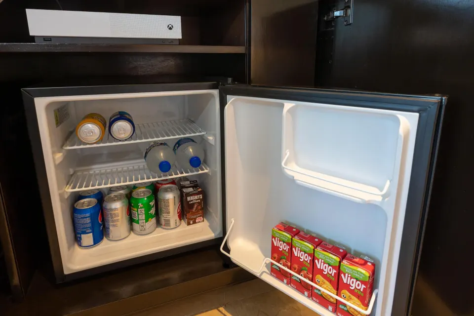 Open minibar with drinks and a game console above at Moon Palace Cancun.