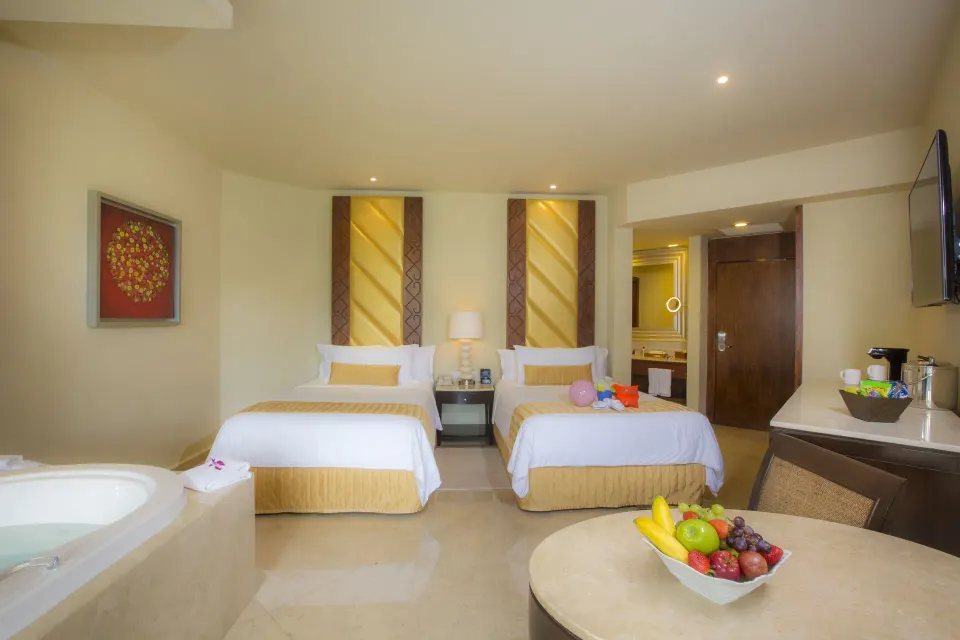 Superior Family Deluxe room with two beds, whirlpool tub and table at Moon Palace Cancun.