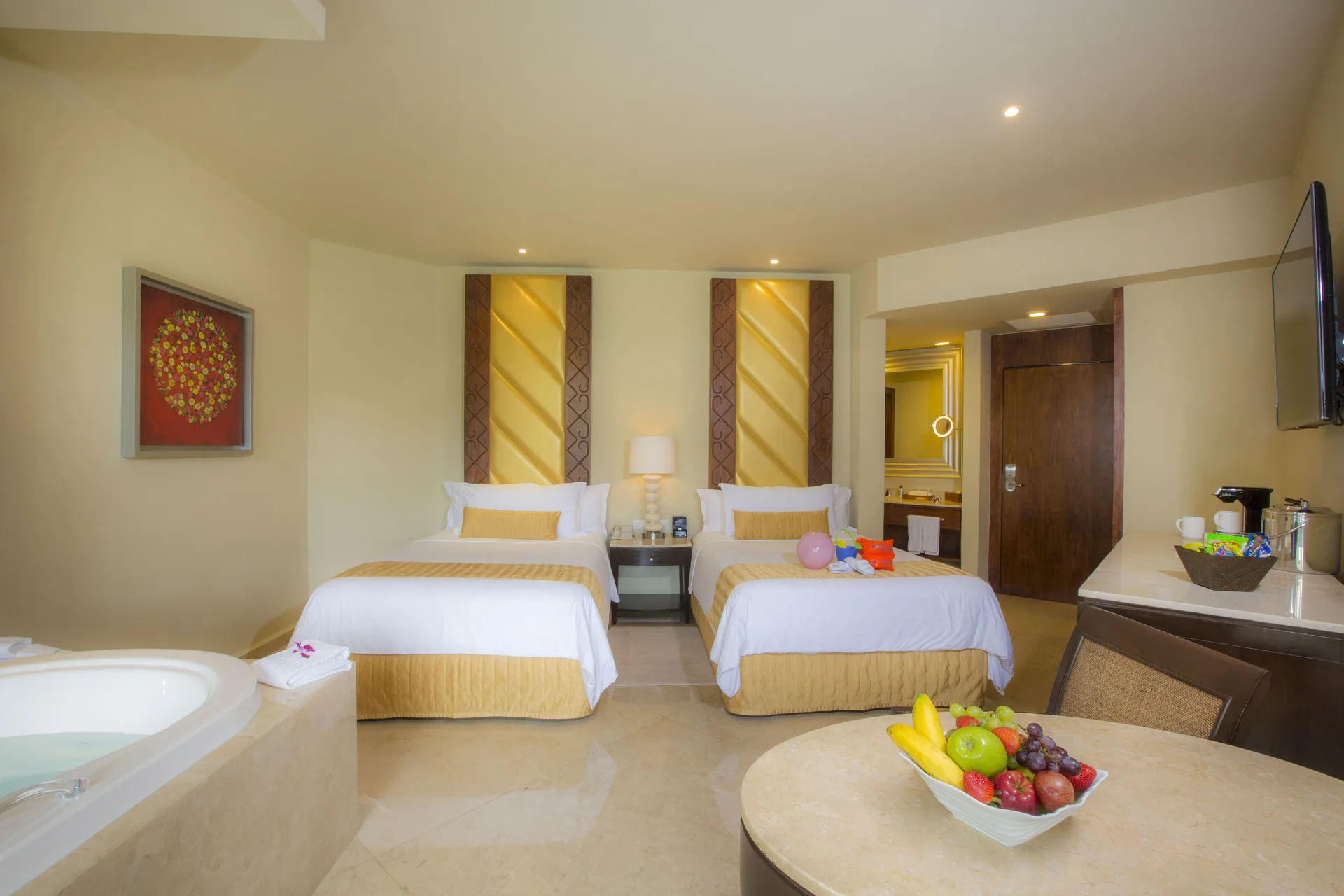 Superior Family Deluxe room with two beds, whirlpool tub and table at Moon Palace Cancun.