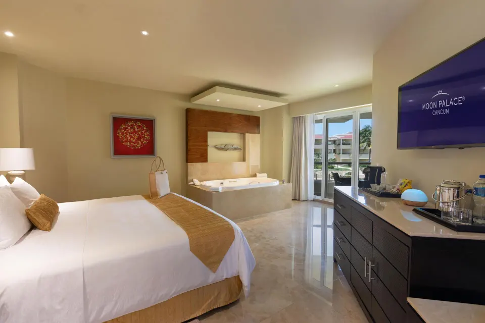 Superior Governor Suite king bed with in-room tub and balcony at Moon Palace Cancun.