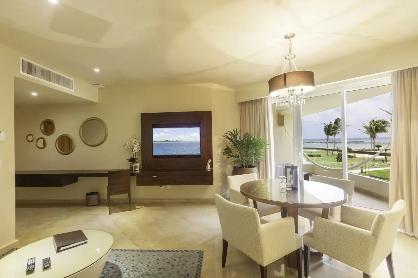 Superior Governor Suite living and dining area with balcony view at Moon Palace Cancun.