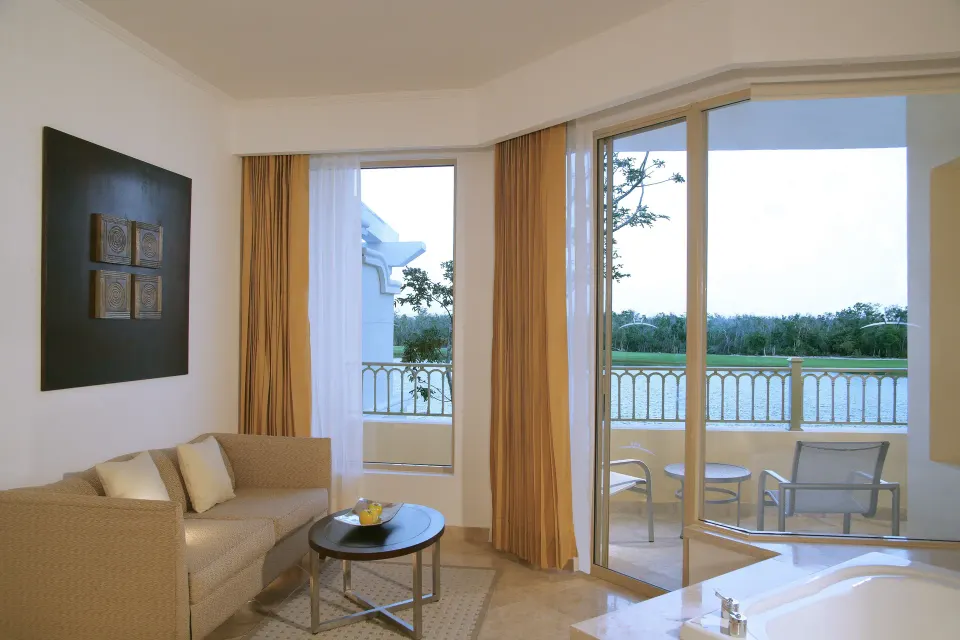 Superior Junior Suite sitting area with balcony and golf course view at Moon Palace Cancun.