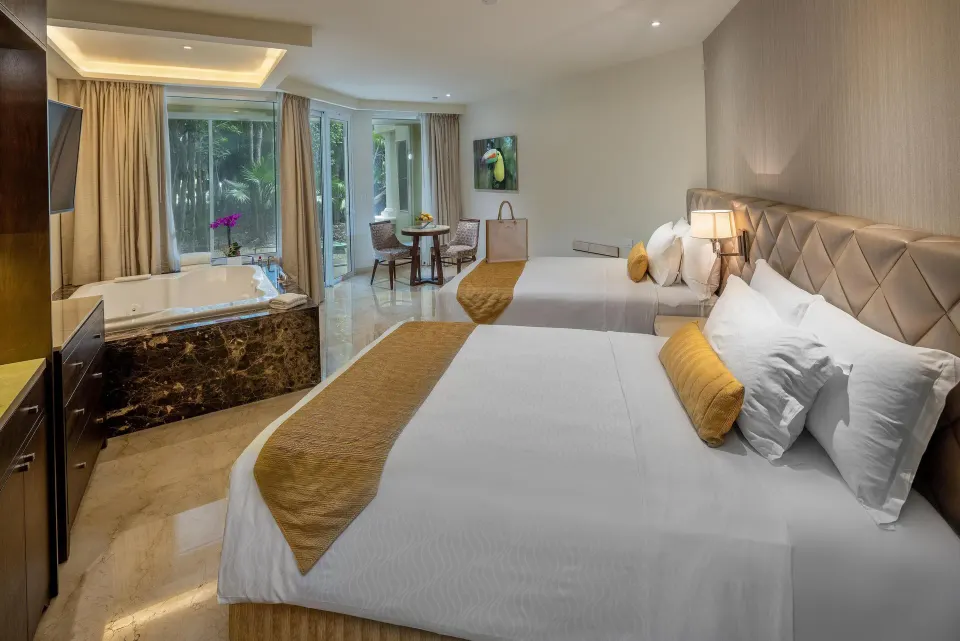 Two double beds and in-room whirlpool tub in a suite bedroom at Moon Palace Cancun.
