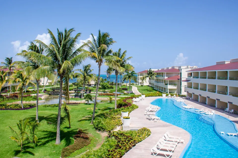 Swim Up Suite pool area with palms, gardens and resort buildings at Moon Palace Cancun.