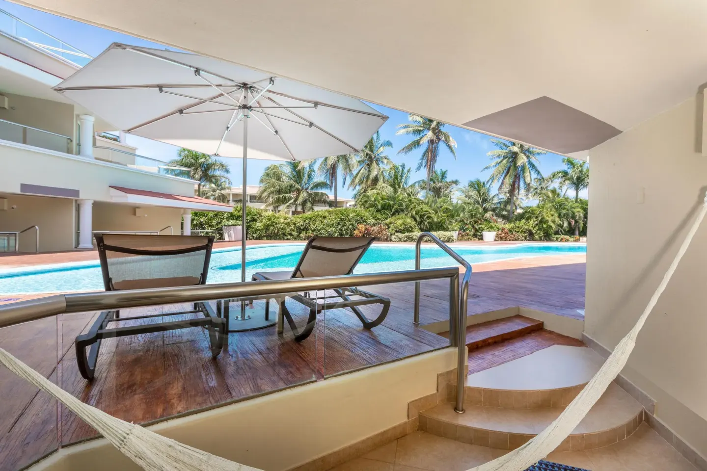 Swim Up Suite terrace with hammock, loungers, umbrella and pool at Moon Palace Cancun.