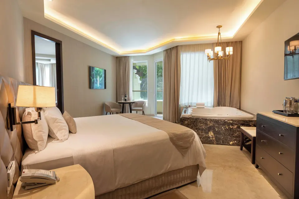 King villa bedroom with whirlpool tub, dresser, and window seating at Moon Palace Cancun.