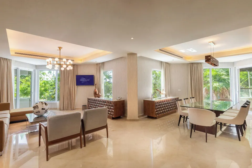 Villa living and dining area with glass table and large windows at Moon Palace Cancun.
