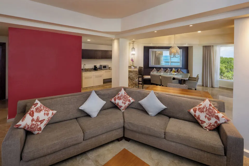 Villa lounge with sectional sofa, kitchenette, and dining area at Moon Palace Cancun.