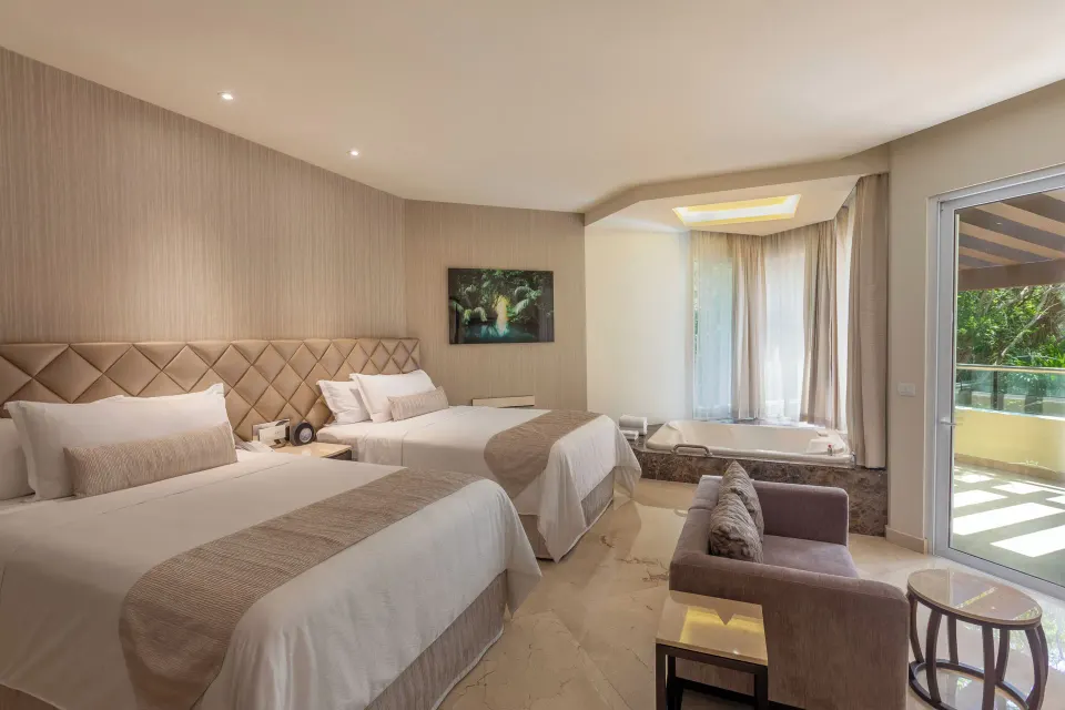 Two-bed villa bedroom with whirlpool tub and balcony door at Moon Palace Cancun.