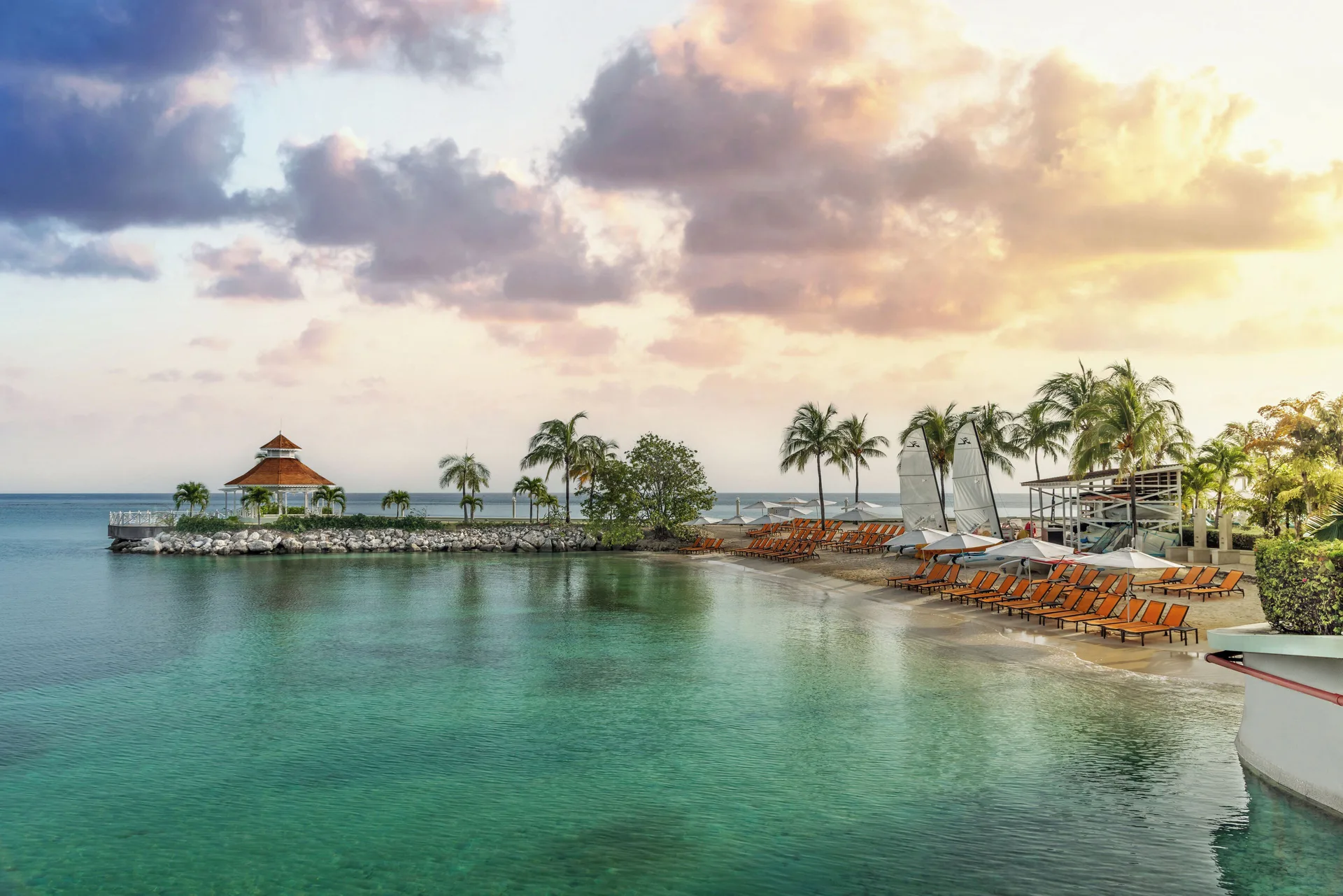 The beach cove has loungers, umbrellas and clear water at Moon Palace Jamaica.