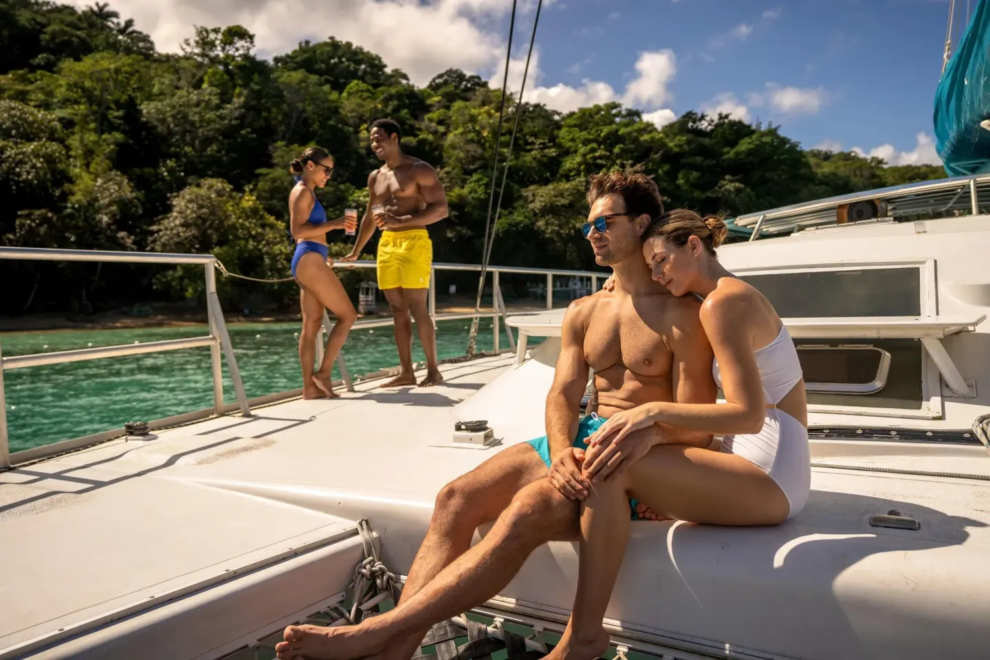 Guests lounging on a catamaran near a green shoreline at Moon Palace Jamaica.