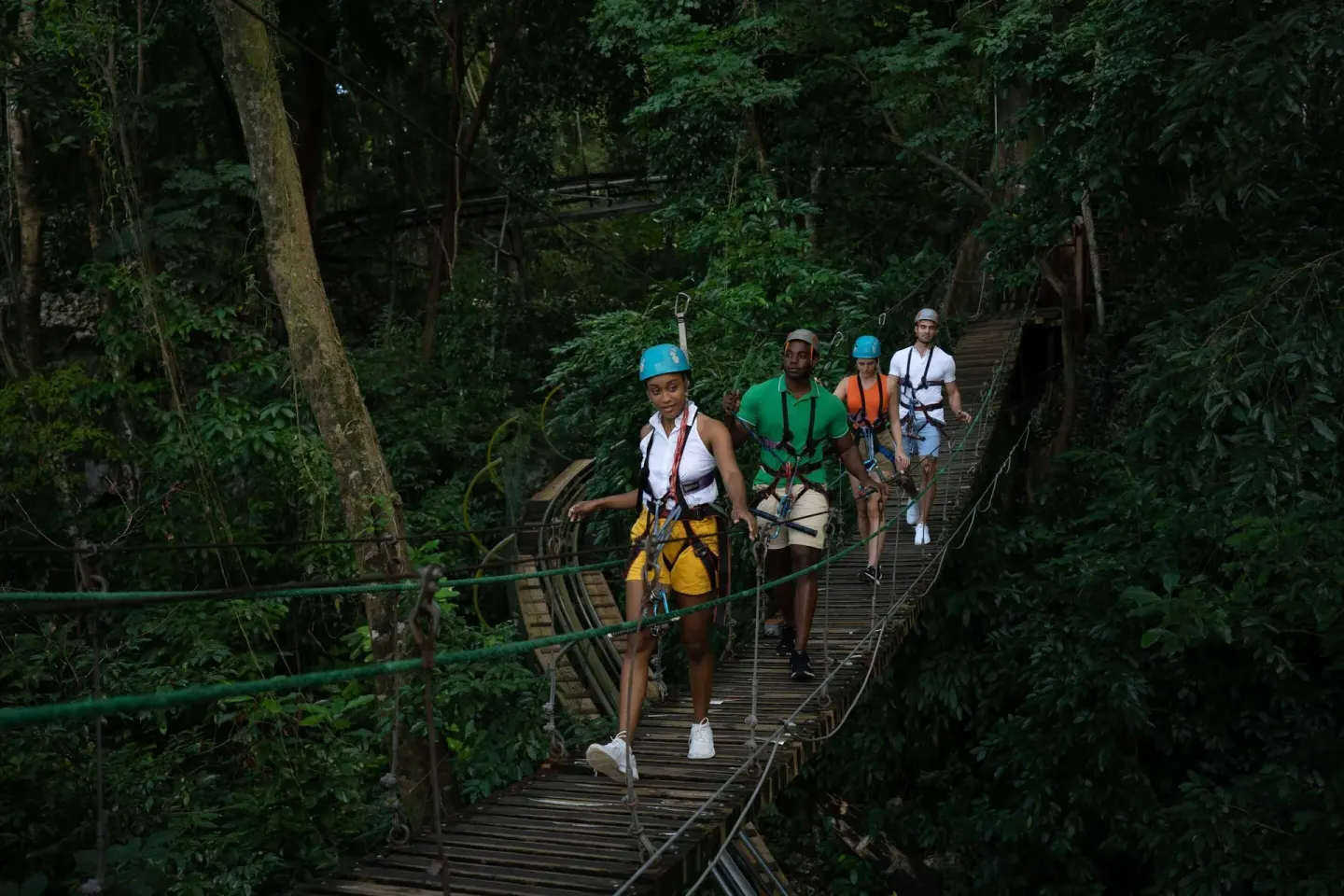 Guests cross a forest suspension bridge near Moon Palace Jamaica.