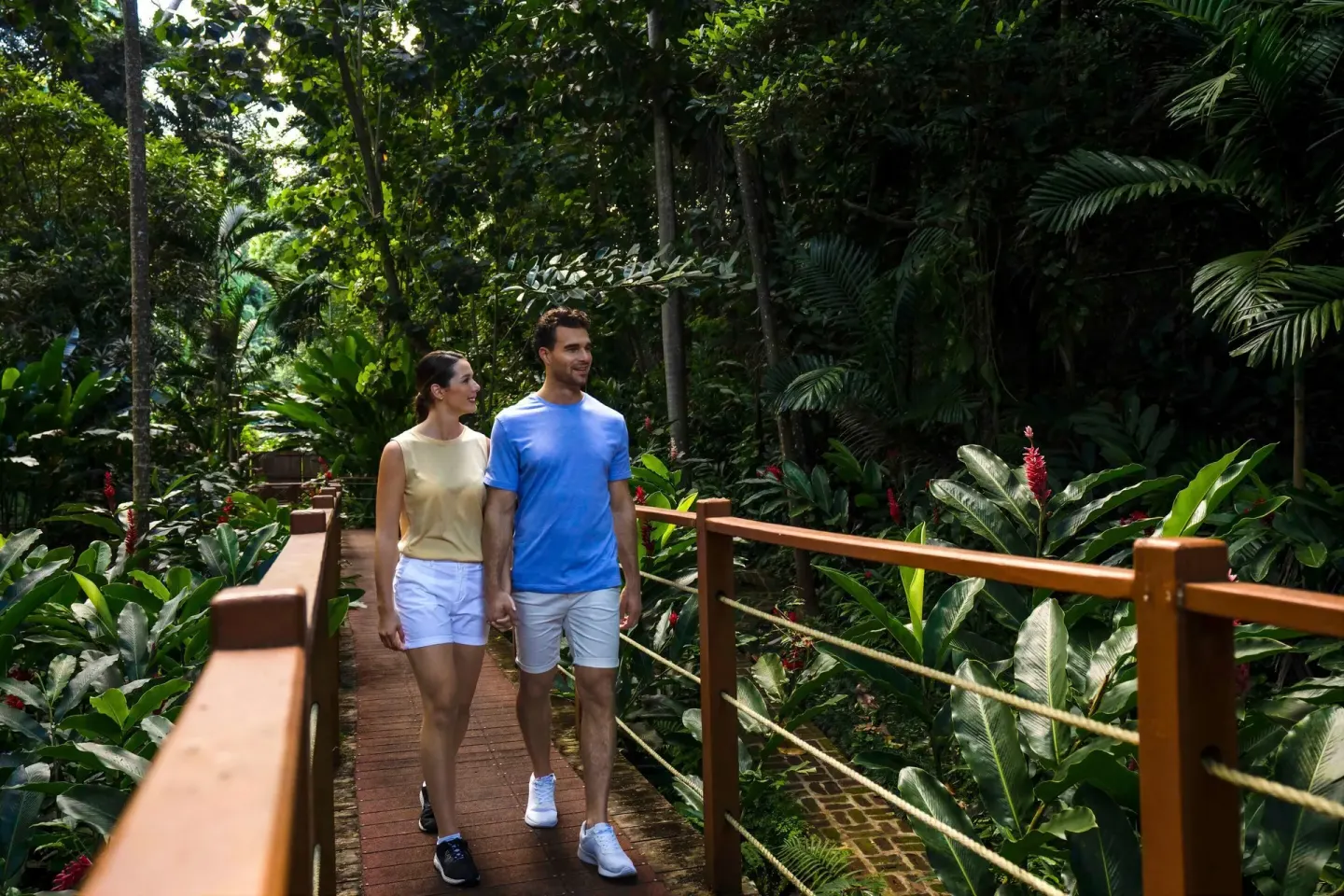 A couple walks along a garden boardwalk at Moon Palace Jamaica.