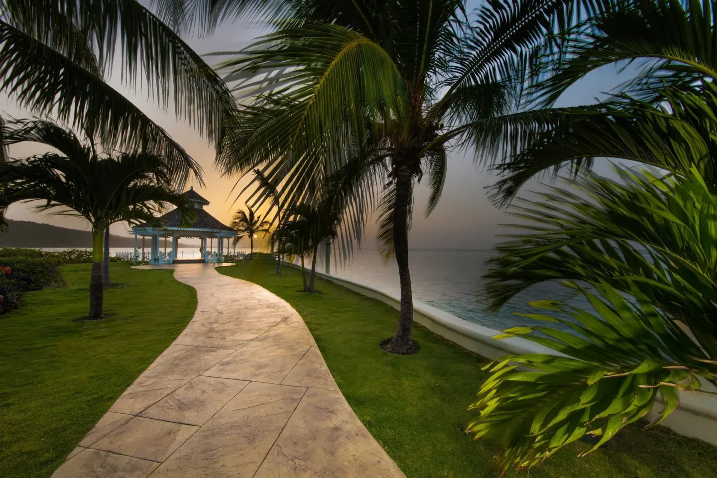 A palm-lined garden path leads to a seaside gazebo at Moon Palace Jamaica.